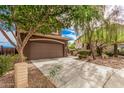 The brown house includes a 2-car garage and a long concrete driveway at 20261 W Desert Bloom St, Buckeye, AZ 85326