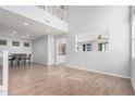 Bright, open living space with a two-story ceiling, wood-look tile floors and a view of the kitchen at 20261 W Desert Bloom St, Buckeye, AZ 85326