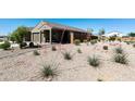 Front yard showcasing drought-tolerant landscaping with native plants and decorative gravel at 21690 N Lynn St, Maricopa, AZ 85138