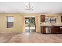 Open kitchen with modern stainless steel appliances, tile flooring, sliding glass doors, and backyard views at 22123 E Vía Del Palo --, Queen Creek, AZ 85142
