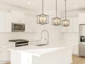 Modern kitchen featuring white cabinets, stainless appliances, and a center island with pendant lighting at 22490 W Tonopah Dr, Surprise, AZ 85387