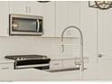 Close-up of kitchen with stainless steel microwave and gas range, accented by a white backsplash at 22490 W Tonopah Dr, Surprise, AZ 85387