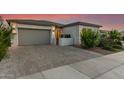 Beautiful gray stucco home boasts a paved driveway and a gated front entrance with desert landscaping at 22609 E Roundup Way, Queen Creek, AZ 85142