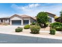 This home features a manicured front yard with lush landscaping and a convenient three-car garage at 2310 W Sienna Bouquet Pl, Phoenix, AZ 85085