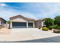 Inviting home showcases a neat front yard with a spacious three-car garage, under a sunny sky at 2310 W Sienna Bouquet Pl, Phoenix, AZ 85085
