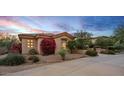 Desert home displaying attractive landscaping, a cozy ambiance with warm lighting under the evening sky at 24158 N 78Th Pl, Scottsdale, AZ 85255
