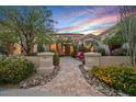 Charming home featuring desert landscape and a tiled walkway to an inviting outdoor seating area at sunset at 24158 N 78Th Pl, Scottsdale, AZ 85255