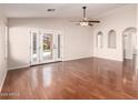 Bright living room with hardwood floors, French doors to the pool, and a ceiling fan at 2503 E Camellia Dr, Gilbert, AZ 85296