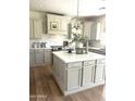 Beautiful kitchen with a large island, white cabinets, stainless steel appliances, and modern lighting at 29966 N 72Nd Dr, Peoria, AZ 85383