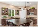 Spacious kitchen features granite countertops, dark wood cabinetry, stainless appliances, and a large island at 31900 N 127Th Ln, Peoria, AZ 85383