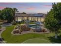Expansive backyard with a rock feature pool, putting green, trampoline, and desert landscaping at 3410 E Inglewood Cir, Mesa, AZ 85213