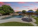 Private backyard pool featuring a rock waterfall, spa, blue umbrellas, and lounge chairs at 3410 E Inglewood Cir, Mesa, AZ 85213