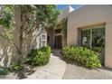 Inviting home entrance with a paved walkway, mature trees, and desert landscaping at 34221 N Boulders Pkwy, Scottsdale, AZ 85266