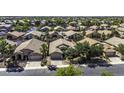 A high angle view showcases a well-maintained residential neighborhood with mature trees and varied rooflines at 43283 W Hillman Dr, Maricopa, AZ 85138