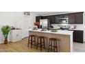 Modern kitchen island with seating and stainless steel appliances at 51134 W Bluejay St, Maricopa, AZ 85139
