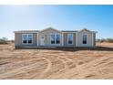 New single-story home boasts a symmetrical design and a freshly landscaped yard under a clear blue sky at 51942 W Sotol Rd, Maricopa, AZ 85139