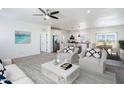 Bright, open-concept living room features modern ceiling fan, updated decor, and flows seamlessly into the kitchen at 51942 W Sotol Rd, Maricopa, AZ 85139