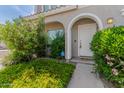Close-up of the front door with a charming arched entryway and mature landscaping at 5232 N 16Th Ln, Phoenix, AZ 85015