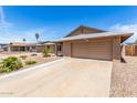 Front view showcasing a two-car garage and spacious driveway at 5320 W Maui Ln, Glendale, AZ 85306
