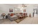 Inviting living room with a cozy sectional sofa, ceiling fan, and neutral decor, perfect for relaxation at 6002 N 124Th Dr, Litchfield Park, AZ 85340