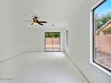 Bright living room featuring neutral tones, ceiling fan, and sliding glass door to back yard at 7037 W Cavalier Dr, Glendale, AZ 85303