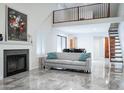 Open-concept living room with fireplace, modern flooring, and staircase to the upper level at 8635 W Country Gables Dr, Peoria, AZ 85381