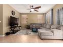 Comfortable living room features a ceiling fan, carpet floors, and ample seating space at 9343 W Quail Ave, Peoria, AZ 85382