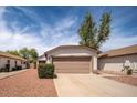Single-story home showcasing a two-car garage and low-maintenance desert landscaping at 10808 W Ruth Ave, Peoria, AZ 85345
