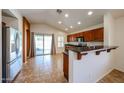 Open kitchen with stainless steel appliances, breakfast bar, and sliding glass doors at 12845 W Milton Dr, Peoria, AZ 85383