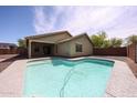 Backyard featuring a refreshing pool, covered patio, and low-maintenance landscaping at 12845 W Milton Dr, Peoria, AZ 85383