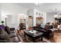 A formal living room featuring hardwood floors, a Persian rug, and a leather furniture set at 16083 W Cambridge Ave, Goodyear, AZ 85395