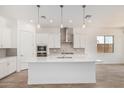 Open kitchen featuring white cabinets, stainless appliances, a large island, and modern lighting at 16494 W Creedance Blvd, Surprise, AZ 85387