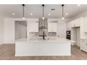 Bright, open kitchen with white cabinets, quartz countertops, and stainless steel appliances at 16550 W Creedance Blvd, Surprise, AZ 85387