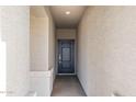 Welcoming front entryway featuring a stylish gray door and neutral stucco walls at 17836 W Mission Ln, Waddell, AZ 85355