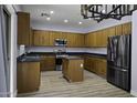 Spacious kitchen features granite countertops, stainless steel appliances, ample wood cabinets and a center island at 20200 N Donithan Way, Maricopa, AZ 85138