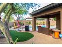 Backyard view showcasing a pool, patio, outdoor furniture, BBQ, and artificial grass at 2038 W Whisper Rock Trl, Phoenix, AZ 85085