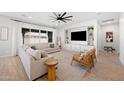 Comfortable living room with large windows, neutral-toned sofa, and a built-in entertainment center at 22728 E Camacho Rd, Queen Creek, AZ 85142