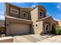 Tan two-story home featuring a two-car garage, tiled roof, and manicured front yard at 2721 E Schiliro Cir, Phoenix, AZ 85032