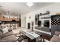Open-concept living room showcasing modern decor, a sleek entertainment center, and hardwood floors that transition to a lovely kitchen at 2721 E Schiliro Cir, Phoenix, AZ 85032