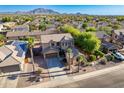 Expansive aerial view showcases this home with solar panels, lush landscaping, and mountain views in a desirable community at 3901 E Packard Dr, Gilbert, AZ 85298