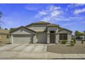 Charming single-story home featuring a three-car garage, desert landscaping, and a welcoming front entrance at 42760 W Magnolia Rd, Maricopa, AZ 85138