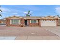Charming single story brick home featuring manicured desert landscaping and an attached two car garage at 4306 E Dragoon Cir, Mesa, AZ 85206