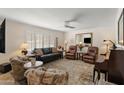 Inviting living room with neutral tones, comfortable seating, shuttered windows, and a ceiling fan at 4306 E Dragoon Cir, Mesa, AZ 85206