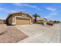 Exterior view of a charming tan home with a two-car garage and desert landscaping at 4434 E Thistle Landing Dr, Phoenix, AZ 85044