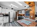 Updated kitchen features stainless steel appliances, white cabinets, and a tile countertop at 466 N Rennick Dr, Apache Junction, AZ 85120