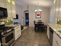 Beautiful kitchen featuring granite countertops, white cabinetry, a dining table and open access to other rooms at 4721 E Abraham Ln, Phoenix, AZ 85050