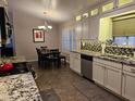 A bright kitchen with white cabinets, granite countertops, and stainless steel appliances, adjacent to a dining area at 4721 E Abraham Ln, Phoenix, AZ 85050