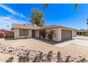 A charming single-story home with desert landscaping and beautiful flowering bushes at 4832 W Golden Ln, Glendale, AZ 85302