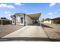 Exterior view of home with a covered parking spot, rock landscaping, and freshly painted facade at 500 N 67Th Ave # 52, Phoenix, AZ 85043