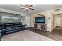 Inviting living area featuring a sectional sofa, wooden-look flooring, and a large television for entertainment at 5801 W Cortez St, Glendale, AZ 85304